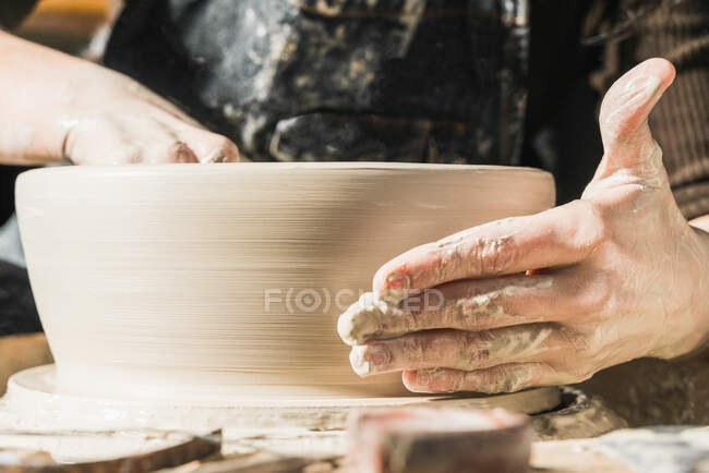 Anonyme Kunsthandwerkerin mit Töpferscheibe beschnitten und in Werkstatt handgefertigtes Steingut geschaffen — Stockfoto