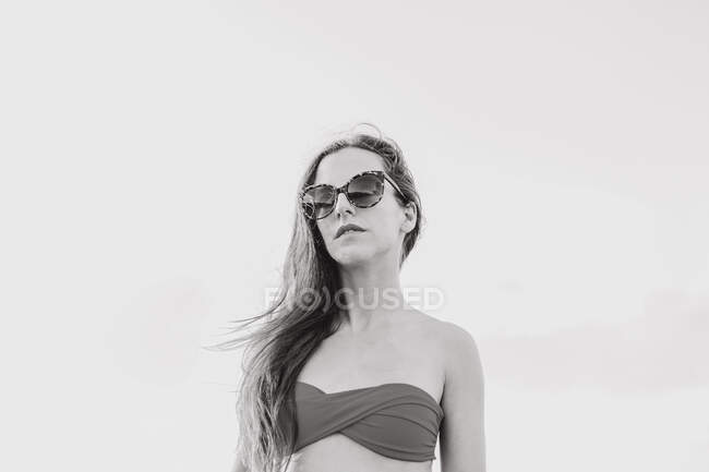 Confiante adolescente de cabelos longos hipster feminino em roupa de verão elegante e óculos de sol desfrutando de férias de verão à beira-mar — Fotografia de Stock