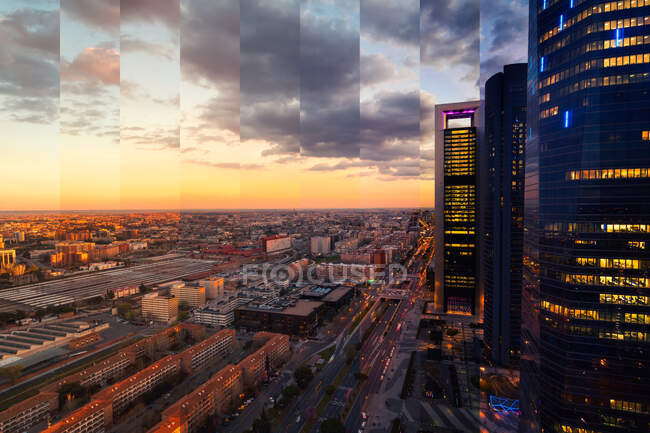 Modern building exteriors against urban roadway with transport traffic under cloudy sky at sundown in Madrid Spain — Stock Photo