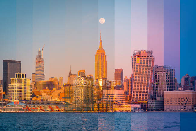 East River em Nova York com arranha-céus contemporâneos sob o céu ensolarado ao pôr-do-sol — Fotografia de Stock