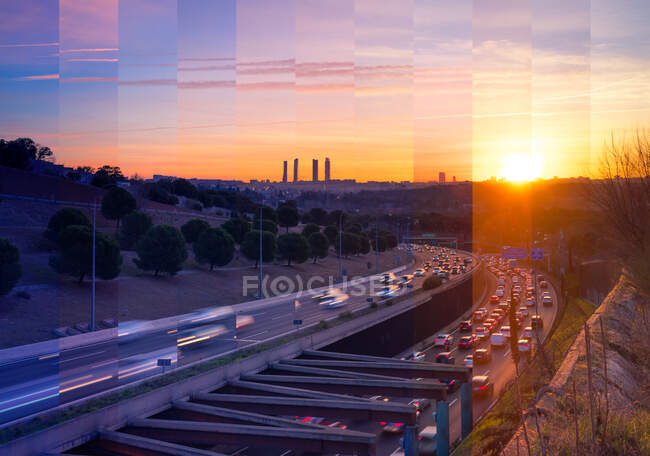 Contemporary skyscraper and multistory house exteriors against roadway and shiny light posts in Madrid at sunset — Stock Photo