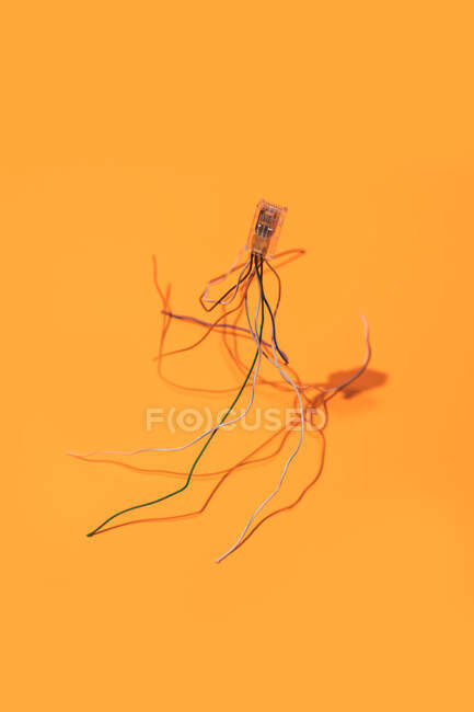 Visão superior layout minimalista de cacho de cabos elétricos multicoloridos no fundo amarelo brilhante — Fotografia de Stock