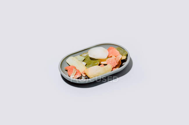 Velhos restos de sabão seco de várias formas e cores em prato de sabão cinza no fundo branco — Fotografia de Stock