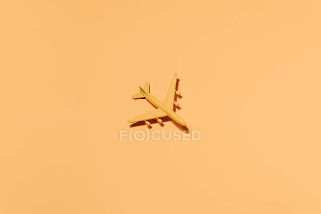 Vista dall'alto di aeroplano giocattolo di plastica disposti su sfondo arancione — Foto stock