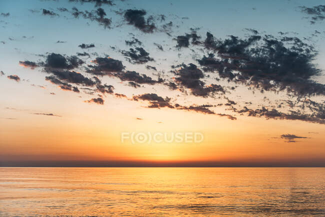 Vista panoramica di vivido cielo arancio tramonto su acqua di mare calma in serata — Foto stock