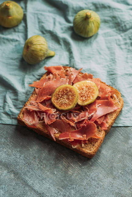 Delicious toast of Iberico ham, cheese and fresh figs on the blue tablecloth, Delicious appetizer, ideal as an aperitif. Healthy food — Stock Photo