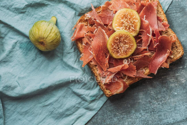 Köstlicher Toast aus iberischem Schinken, Käse und frischen Feigen auf der blauen Tischdecke, köstliche Vorspeise, ideal als Aperitif. Gesunde Ernährung — Stockfoto