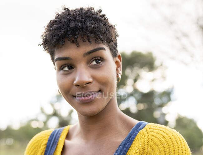 Glad African American female with Afro hairstyle and in trendy outfit in park — Stock Photo
