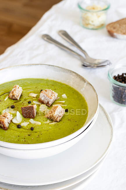 Dall'alto di zuppa di crema di zucchine buonissime con crostini in ciotola serviti sul tavolo a casa — Foto stock