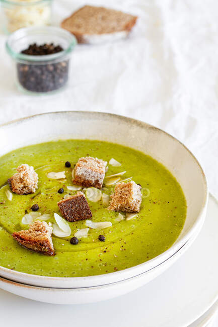 De dessus de délicieuse soupe à la crème de courgettes avec croûtons dans un bol servi sur la table à la maison — Photo de stock