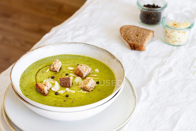 From above of yummy zucchini cream soup with croutons in bowl served on table at home — Stock Photo