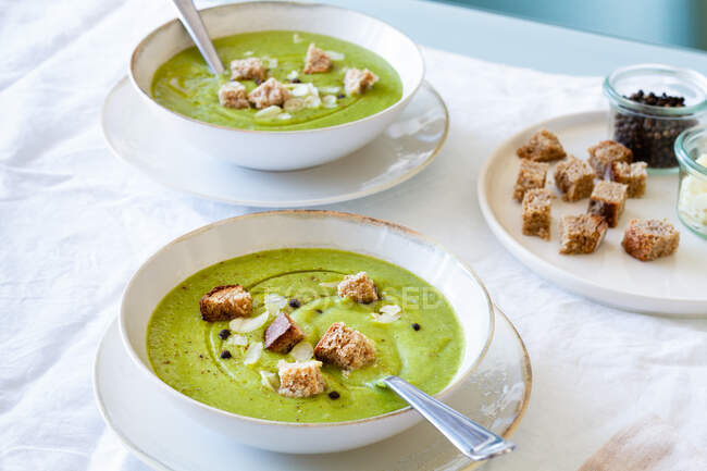 From above of yummy zucchini cream soup with croutons in bowls served on table at home — Stock Photo