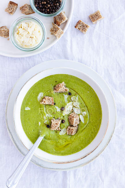Dall'alto di zuppa di crema di zucchine buonissime con crostini in ciotola serviti sul tavolo a casa — Foto stock