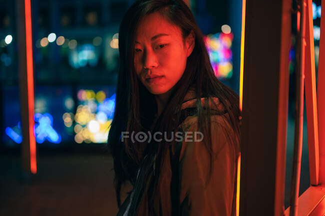 Ritratto di ragazza asiatica in piedi vicino alla luce al neon di notte sulla strada — Foto stock