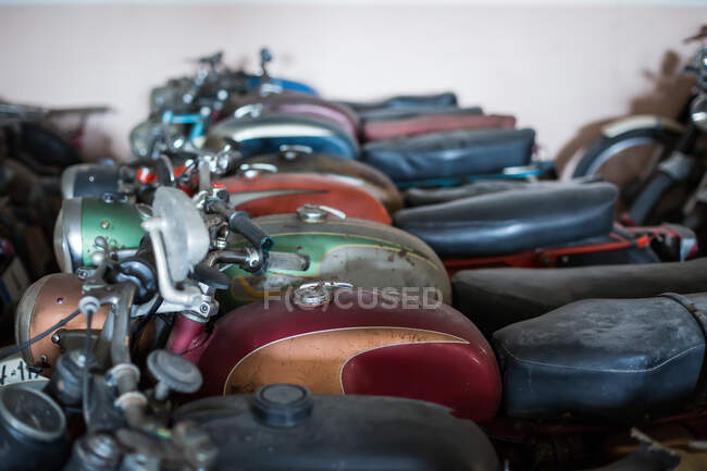 Many old fashioned damaged rusty motorcycles placed in rows in repair service workshop — Stock Photo