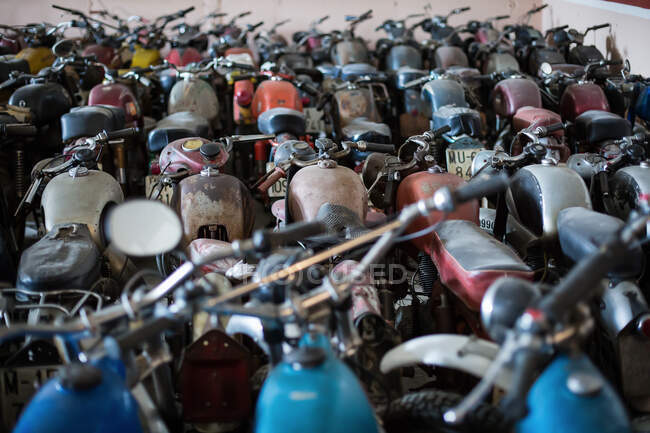 Many old fashioned damaged rusty motorcycles placed in rows in repair service workshop — Stock Photo
