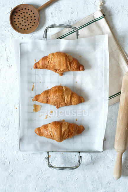 Top view of yummy fresh croissants placed on metal tray on table in kitchen — Stock Photo