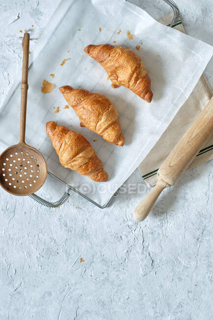 Draufsicht auf leckere frische Croissants auf Metalltablett auf dem Tisch in der Küche — Stockfoto