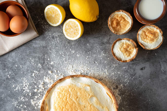 Top view of appetizing meringue pie served on marble table with fresh lemons in kitchen — Stock Photo