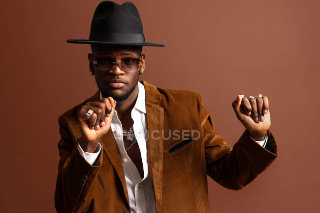 Junger afroamerikanischer Mann in trendiger Kleidung und Hut tanzt und schaut weg — Stockfoto