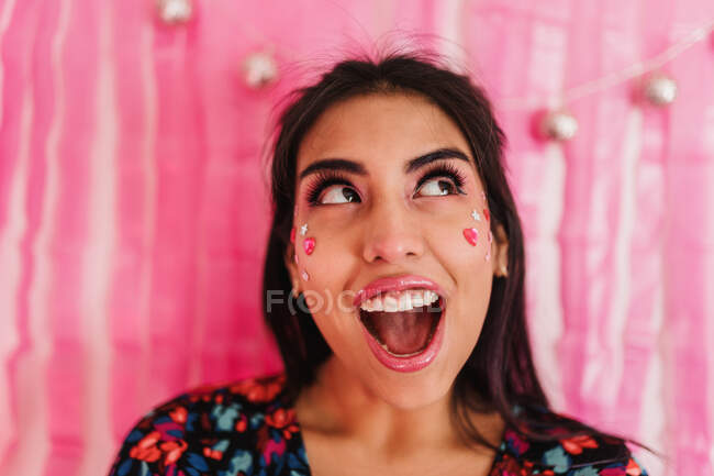 Mädchen mit rosa Farben, die mit überraschtem Gesichtsausdruck nach oben schauen — Stockfoto