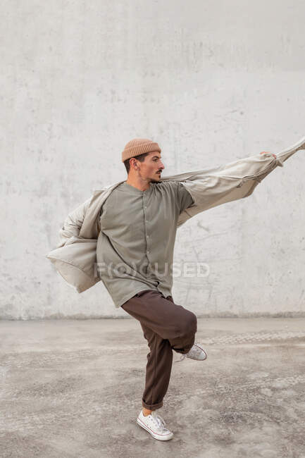 Vue latérale du talentueux danseur masculin breakdance dans un passage spacieux en zone urbaine — Photo de stock
