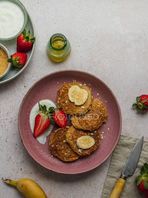 Teller von oben mit Bananen-Pfannkuchen und ein paar Erdbeeren — Stockfoto