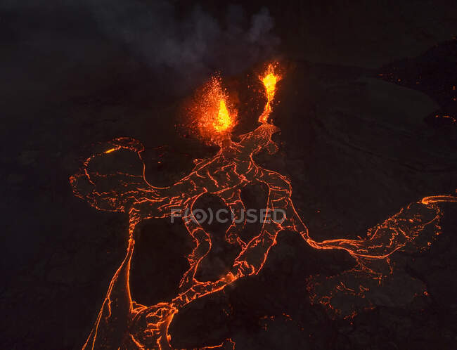 De cima magma faíscas para fora do buraco do vulcão e correr como rios de lava sobre o chão na Islândia — Fotografia de Stock
