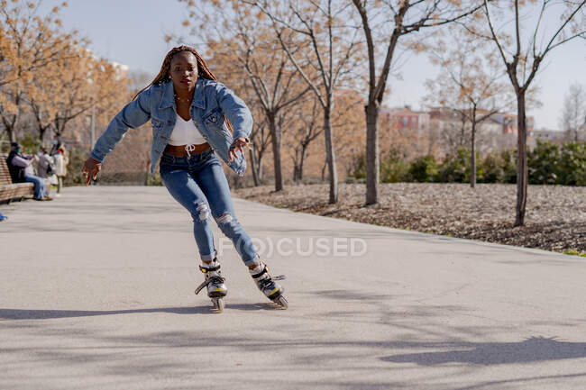 African American female rollerblading along street on sunny day in summer and enjoying weekend in city — Stock Photo