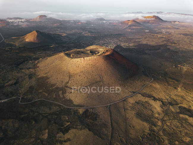 Vue aérienne à couper le souffle sur les montagnes volcaniques et les routes courbes en terrain montagneux sur Lanzarote — Photo de stock