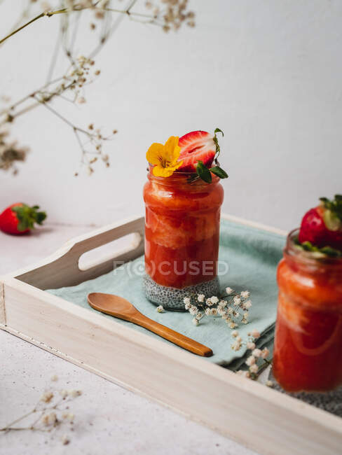 Nahaufnahme eines leckeren Erdbeer-Smoothies mit gelber Blütengarnitur — Stockfoto