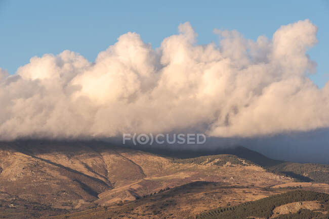 Majestuosa vista del pico montañoso bajo el cielo nublado del atardecer en el Parque Nacional Sierra de Guadarrama - foto de stock