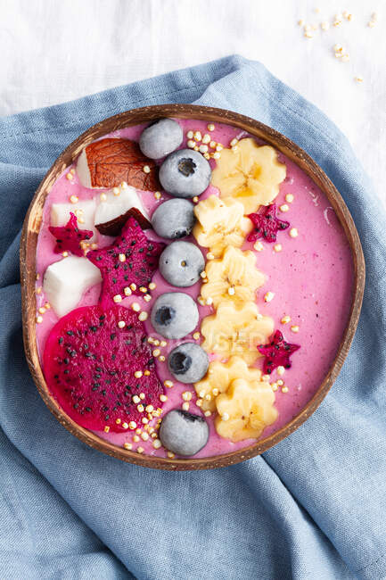 From above of power bowl full of tasty smoothie near ripe banana and dragon fruit slices with blueberries for breakfast — Stock Photo