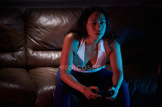 Концентрований геймер використовує майданчик радості і грає у відеоігри в темній кімнаті — стокове фото