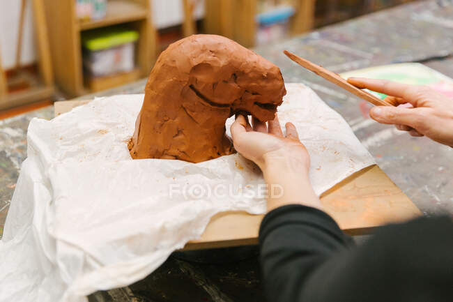 Crop unrecognizable female ceramist using clay and creating handmade earthenware in art studio — Stock Photo
