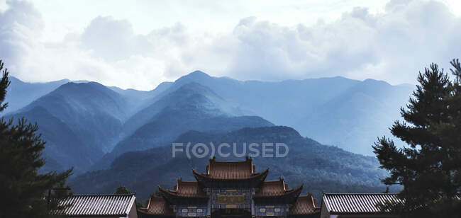 Часть изогнутой крыши древнего буддийского храма, расположенного в горах Юньнаня — стоковое фото