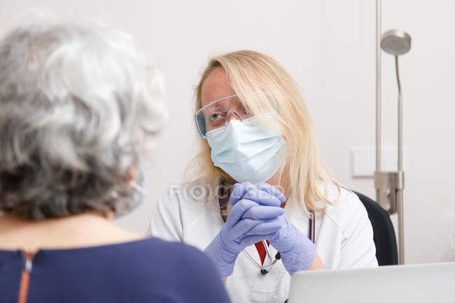 Doctora atendiendo a una paciente en su consultorio médico - foto de stock