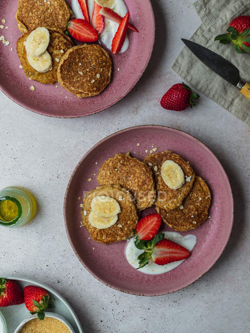 Top view plate with banana pancakes and a few pieces of strawberries — Stock Photo