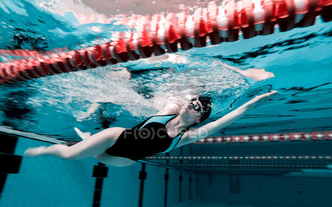 Donna che striscia in una piscina preparandosi per una gara — Foto stock
