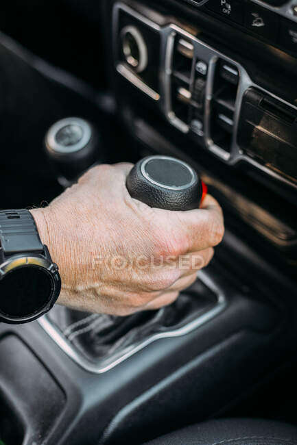 Crop view of anonymous man with her hand on the gear shift of an off-road car — Photo de stock
