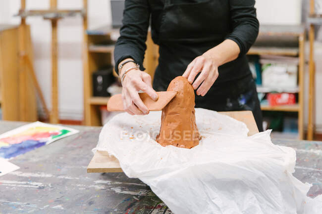 Врожай невизначений жіночий кераміст з використанням глини та створення глиняного посуду ручної роботи в художній студії — стокове фото