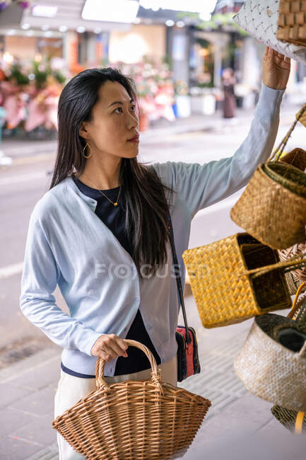 Hermosa chica asiática en floristería comprando una cesta - foto de stock