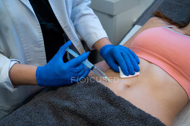 Более того, анонимный профессиональный косметолог делает инъекции женщине во время лечения целлюлитом в клинике красоты — стоковое фото