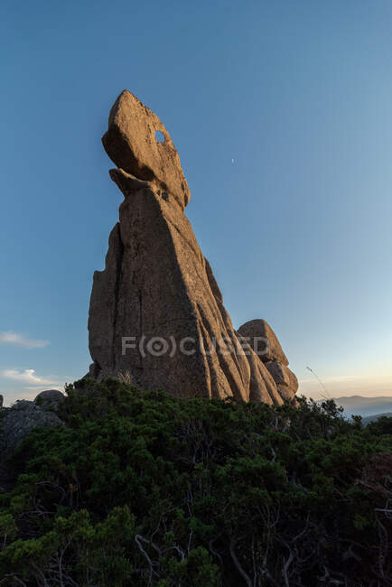 Desde abajo de la formación de piedra ornamental situada en las tierras altas del Parque Nacional Sierra de Guadarrama en el cielo azul - foto de stock