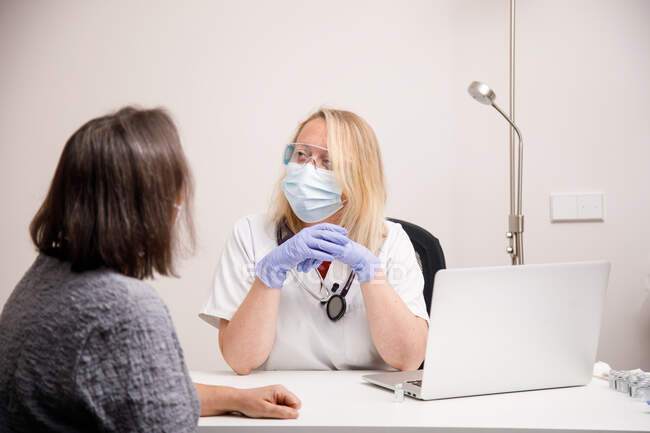 Жінка-лікар, яка відвідує пацієнта в її медичному кабінеті — стокове фото