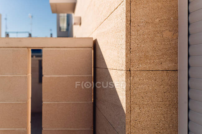 Alvenaria contemporânea edifício exterior com sombra na parede sob o céu azul na cidade no dia ensolarado — Fotografia de Stock
