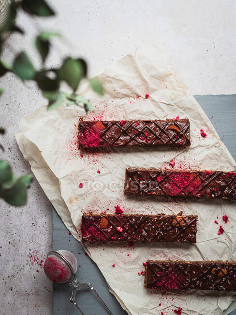 Close up of several chocolate bars with raspberry on a table — Stock Photo