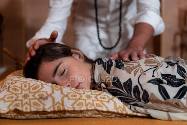 Male spiritual therapist rubbing hands and touching relaxed female head with back during alternative therapy — Stock Photo