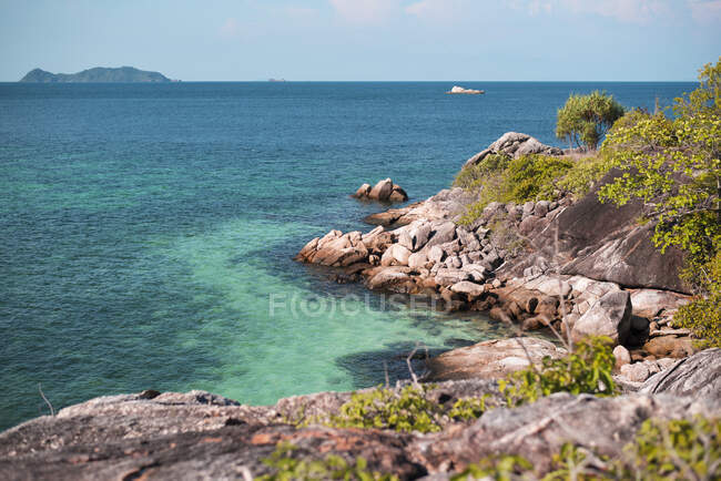 Breathtaking scenery of calm sea and rough rocky coastline under blue sky in summer in Thailand — Stock Photo