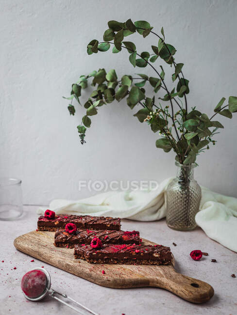 Close up of several chocolate bars with raspberry on a table — Stock Photo